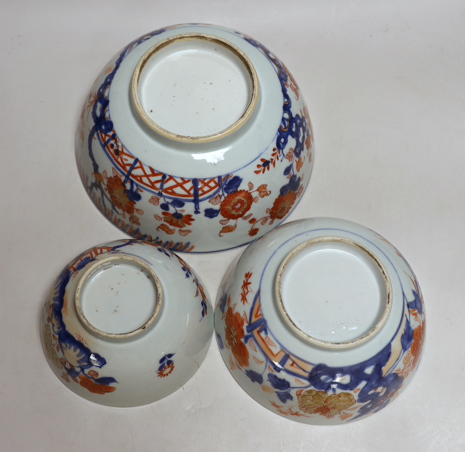 A graduated set of three Chinese Imari bowls, Qianlong period, hand painted with flowers, the largest 23cm in diameter